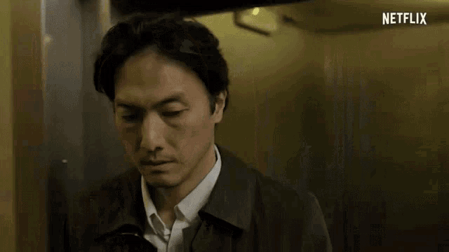 a man in a suit and tie is standing in an elevator .