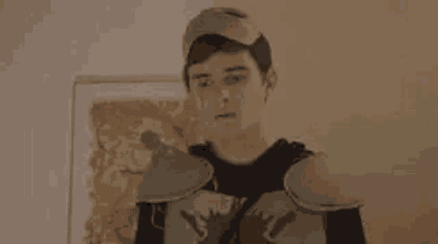 a young man is wearing a knight costume and a hat .
