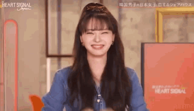 a woman in a blue shirt is smiling and laughing .