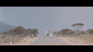 a blurred image of a road with trees on the side