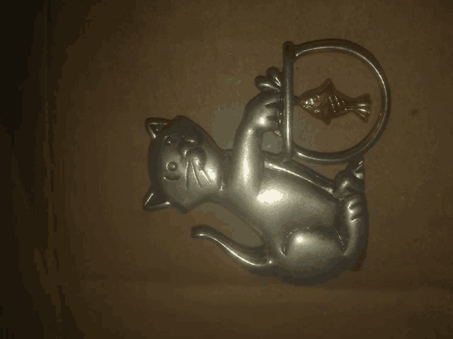 a metal cat holding a fish in its mouth