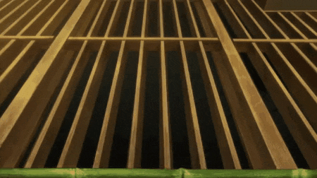 a wooden fence with black bars and a green border