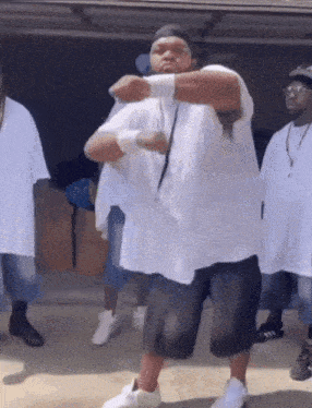a group of men in white shirts are dancing