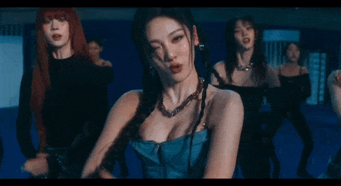 a group of women are dancing together in a dark room in a video .