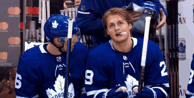 two toronto maple leafs players are sitting on the bench
