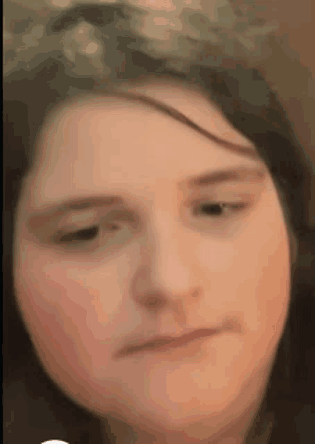 a close up of a woman 's face with a serious look on her face .