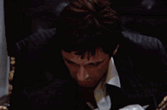 a man in a suit and tie is laying on a bed with his head down