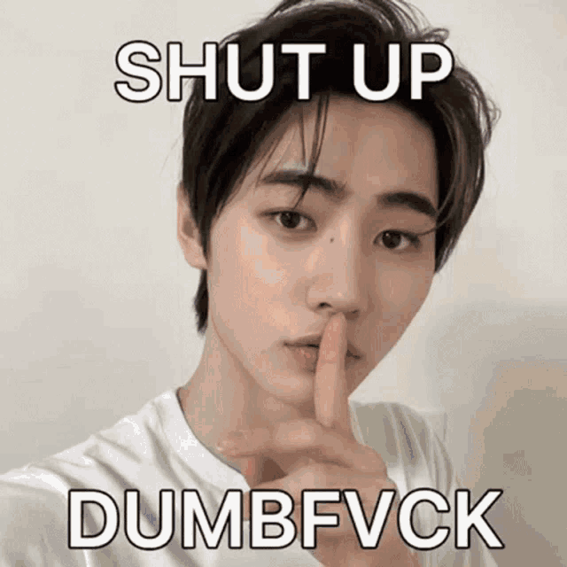 a young man holds his finger to his mouth with the words shut up dumbfvck below him