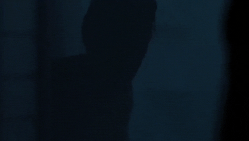 a close up of a person 's face with purple eyes in the dark .