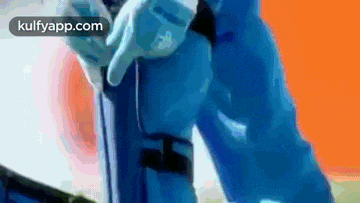 a man in a blue suit is holding a gun in his hand .