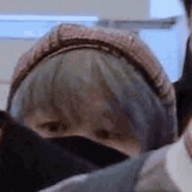 a close up of a person wearing a hat and a mask on a plane .