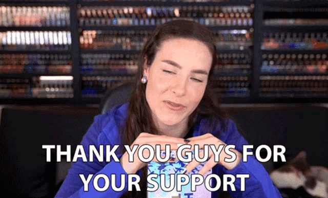 a woman says thank you guys for your support in front of a shelf full of books