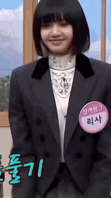 a woman wearing a suit and a name tag with korean writing on it .