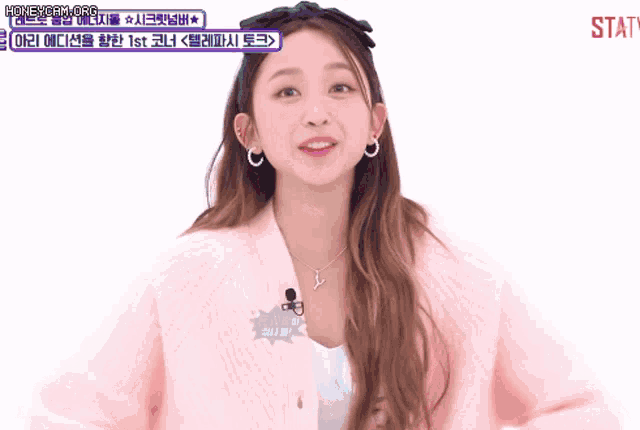 a girl wearing a pink jacket has a sign that says statv