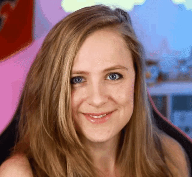 a woman with blonde hair and blue eyes is smiling