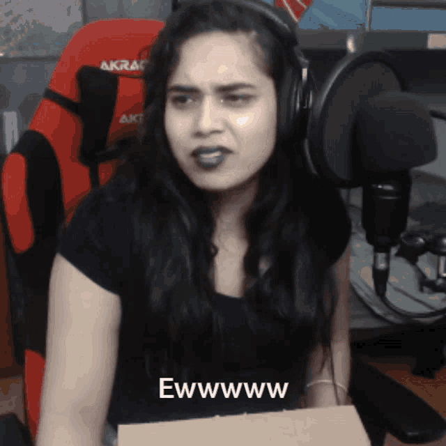 a woman wearing headphones says ewwwwww while holding a box