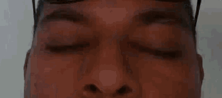a close up of a man 's face with his eyes closed and sunglasses on .