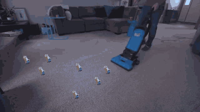 a person is using a blue hoover vacuum cleaner
