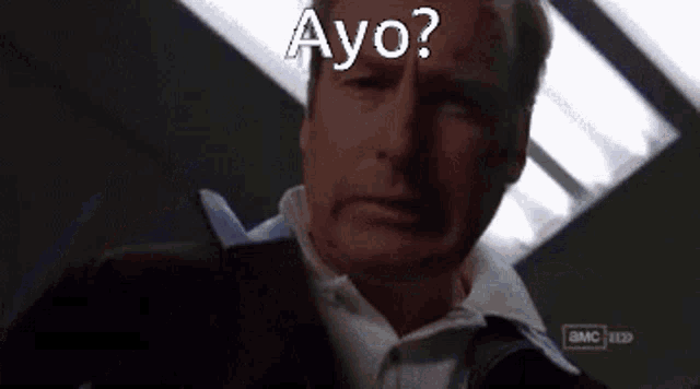 a man looking at a cell phone with the words ayo on the bottom
