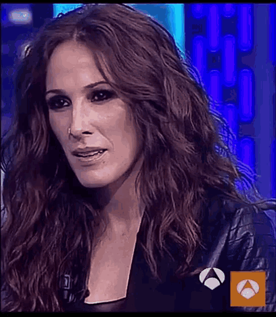 a close up of a woman 's face with a spanish logo on the bottom left