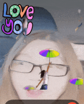 a woman wearing glasses is holding a rainbow colored umbrella with the words love you above her head