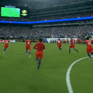 a group of soccer players are playing on a field with a goal sign in the background