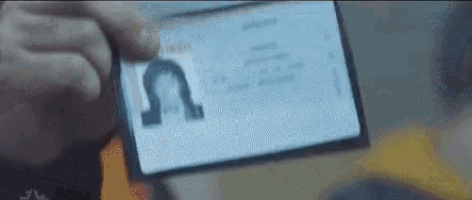 a close up of a person holding a cell phone with a id card on it .