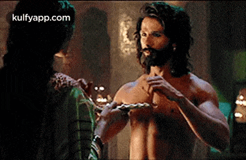 a man with a beard and long hair is standing next to a woman .