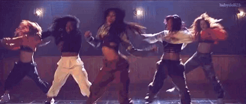 a group of women are dancing on a dance floor .