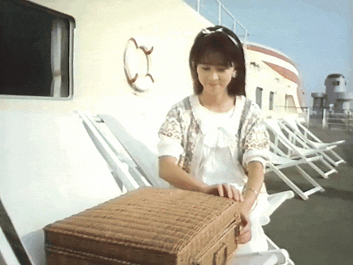 a woman in a white dress is standing next to a suitcase