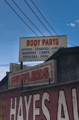 a sign for body parts hangs above a hayes auto shop