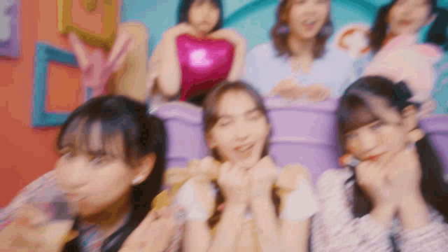 a group of young women are sitting on a roller coaster and laughing .
