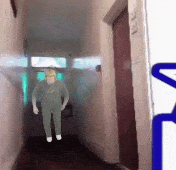 a man in a hard hat is walking down a hallway in front of a door
