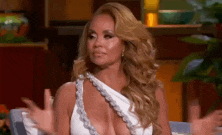 a woman in a very revealing white dress is sitting on a couch .