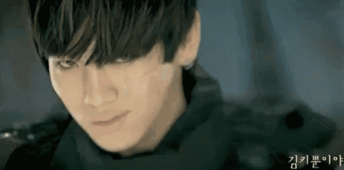 a close up of a young man 's face with a black jacket on .