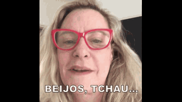 a woman wearing red glasses is making a funny face and saying beijos , tchau .
