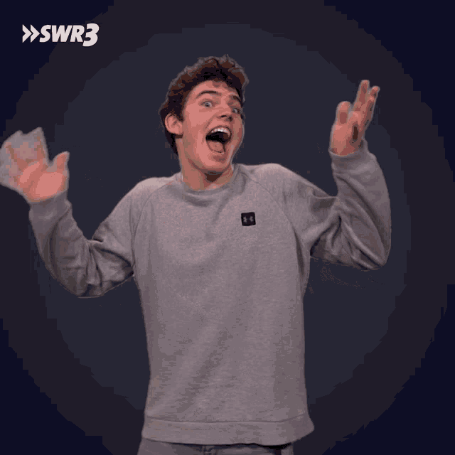 a man in a grey under armour sweatshirt is holding money