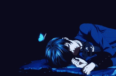 a man in a blue suit is laying down with a butterfly on his head