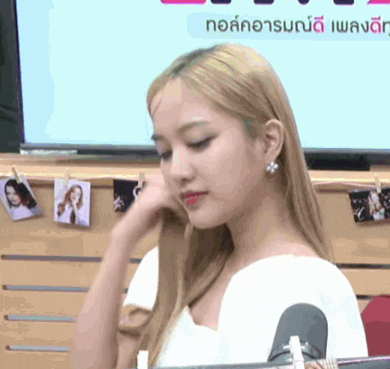 a woman in a white shirt is sitting in front of a sign that says ' no '
