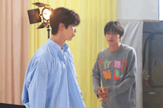 two men are standing next to each other and one has a sweater that says strong will