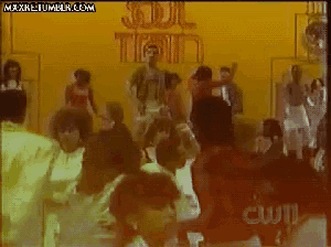 a group of people are dancing in front of a yellow wall that says soul train