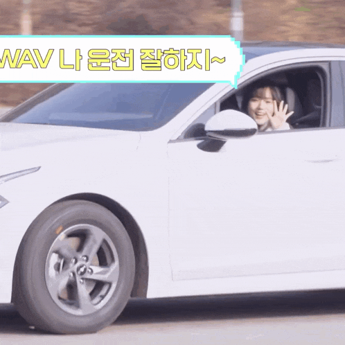 a woman is driving a white car with a sign that says wav on it