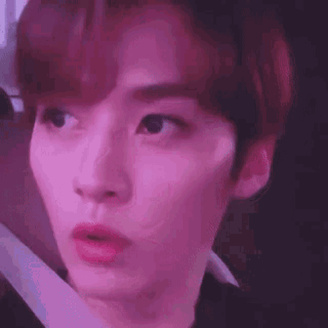 a close up of a person 's face with a pink background .