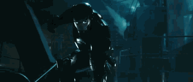 a man in a superhero costume is standing in a dark room