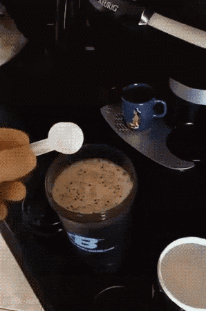 a person is using a toothbrush to brush a cup of coffee