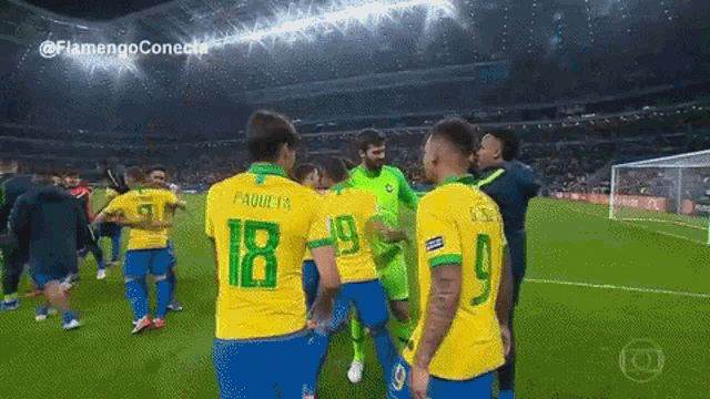 a group of soccer players on a field one of whom has the number 18 on his jersey