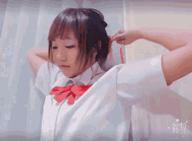 a girl wearing a white shirt and a red bow tie has the time of 10:12