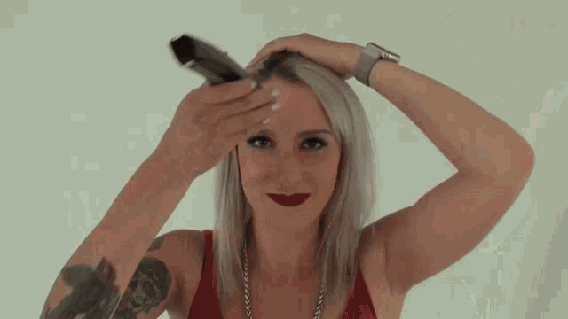 a woman is smiling while holding a hair straightener in front of a bergmann sign