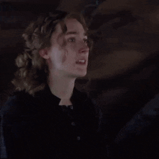 a woman is clapping her hands in the dark .