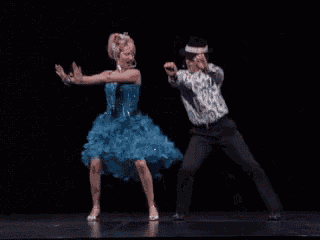 a man and a woman are dancing together on stage